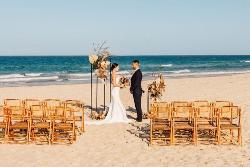 Couple exchanging vows at Sand Key Park with floral details and coastal light